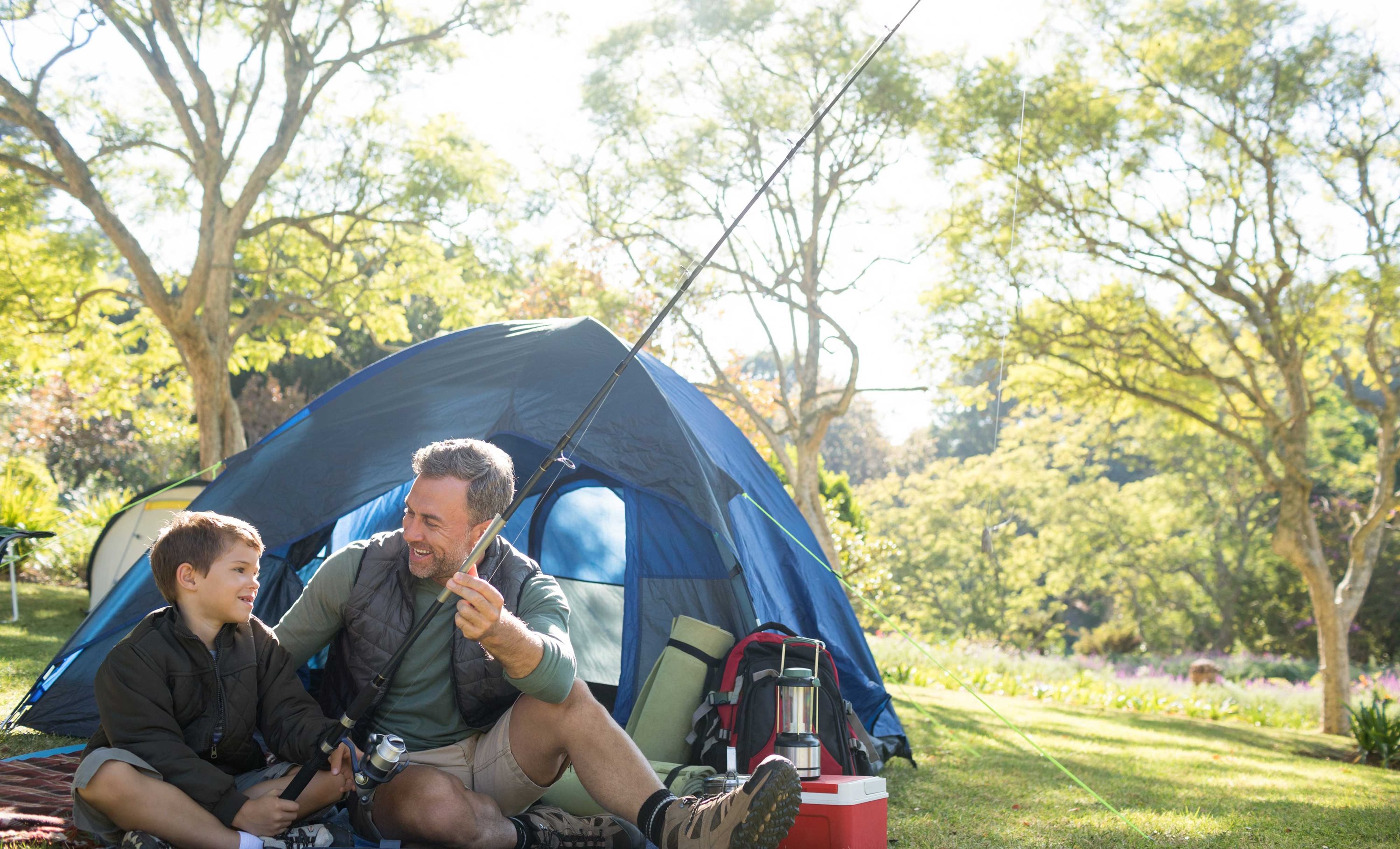 Two campers sitting near a tent.