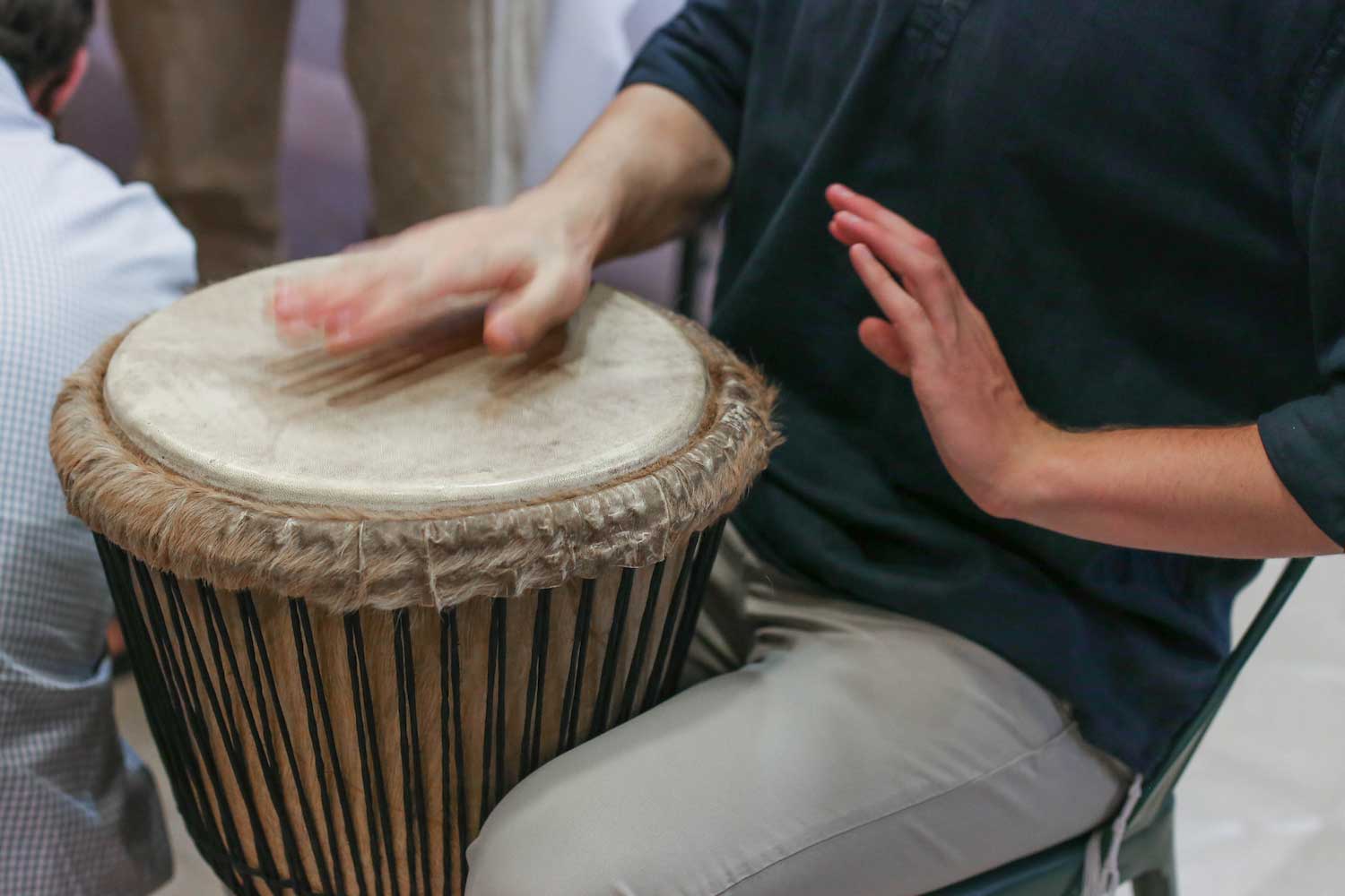 A person beating a drum with their hands.