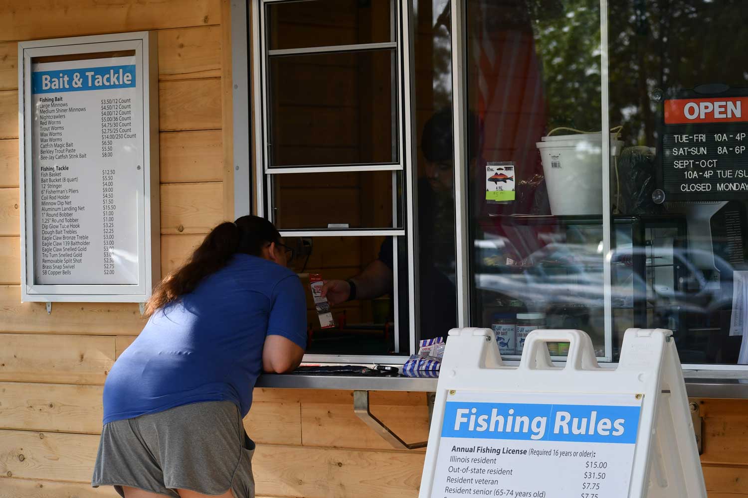 Person talking to staff member at bait shop.