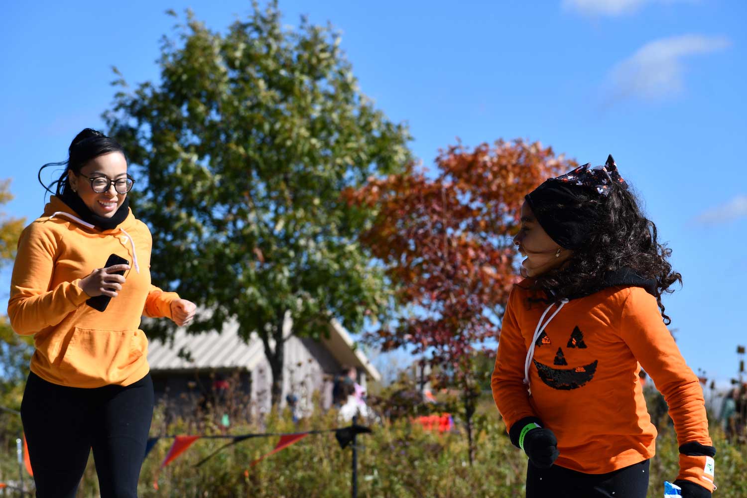 A child looking back at an adult as they both run down a trail.