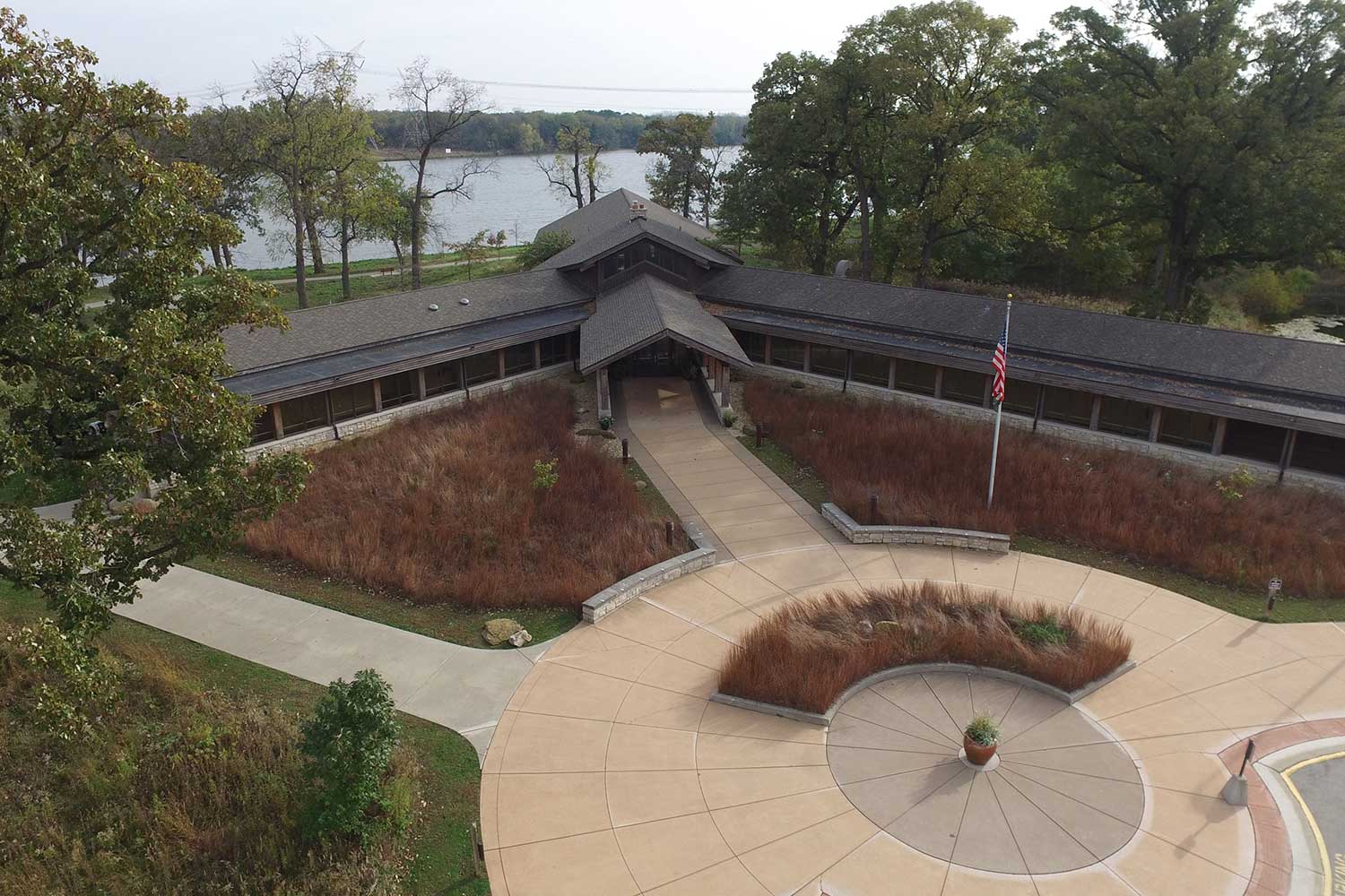 An aerial view of the exterior of Four Rivers Environmental Education Center with a river behind it.