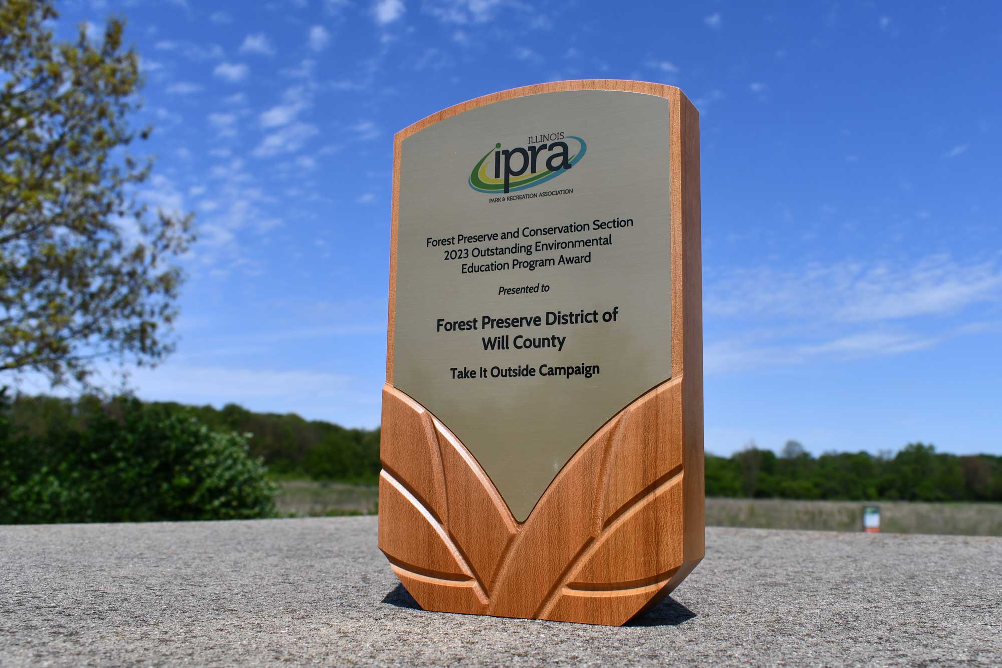 An award plaque taken outside with a clear blue sky background.