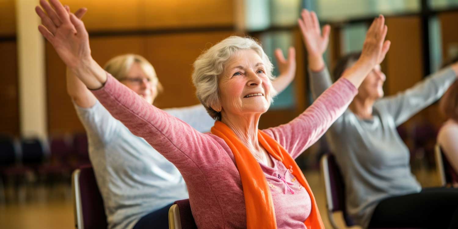 Women sitting in chairs with arms outstretched in a yoga pose.