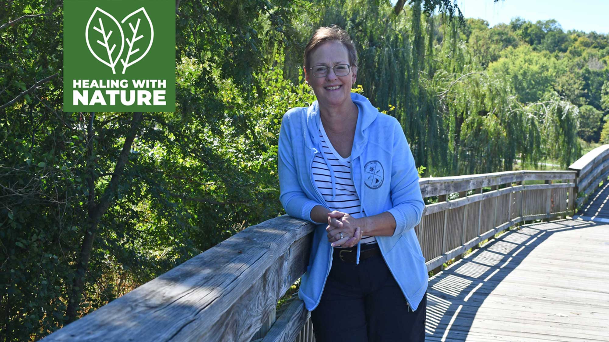 A woman stands on a bridge. 