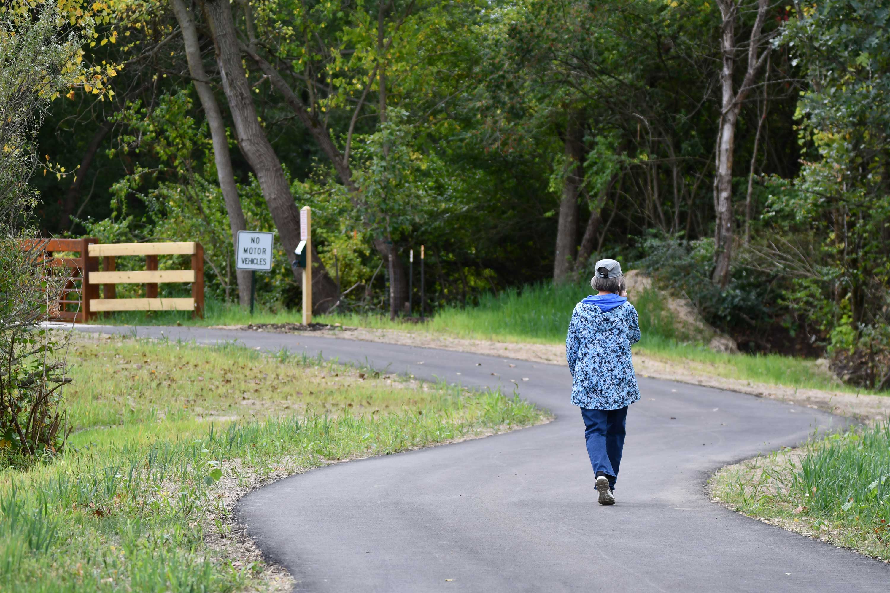 A person walking on a paved trail.