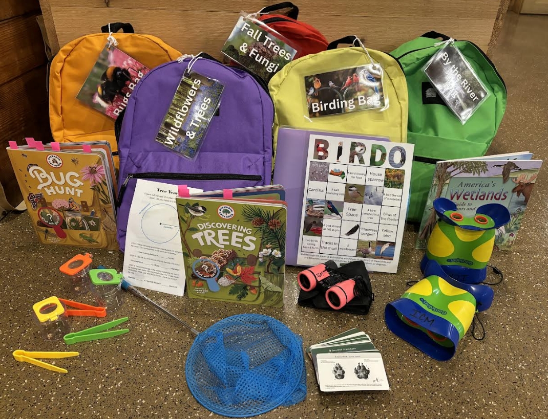 Various nature-themed backpacks arranged in a display, each open to reveal its contents.