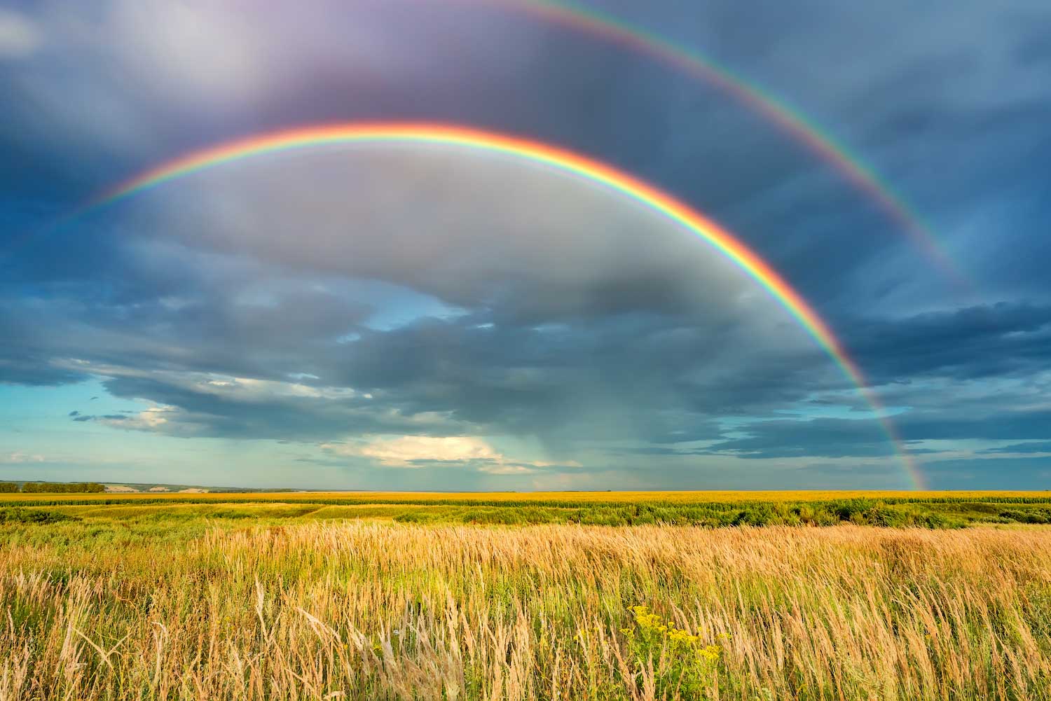 A double rainbow over a prairie.