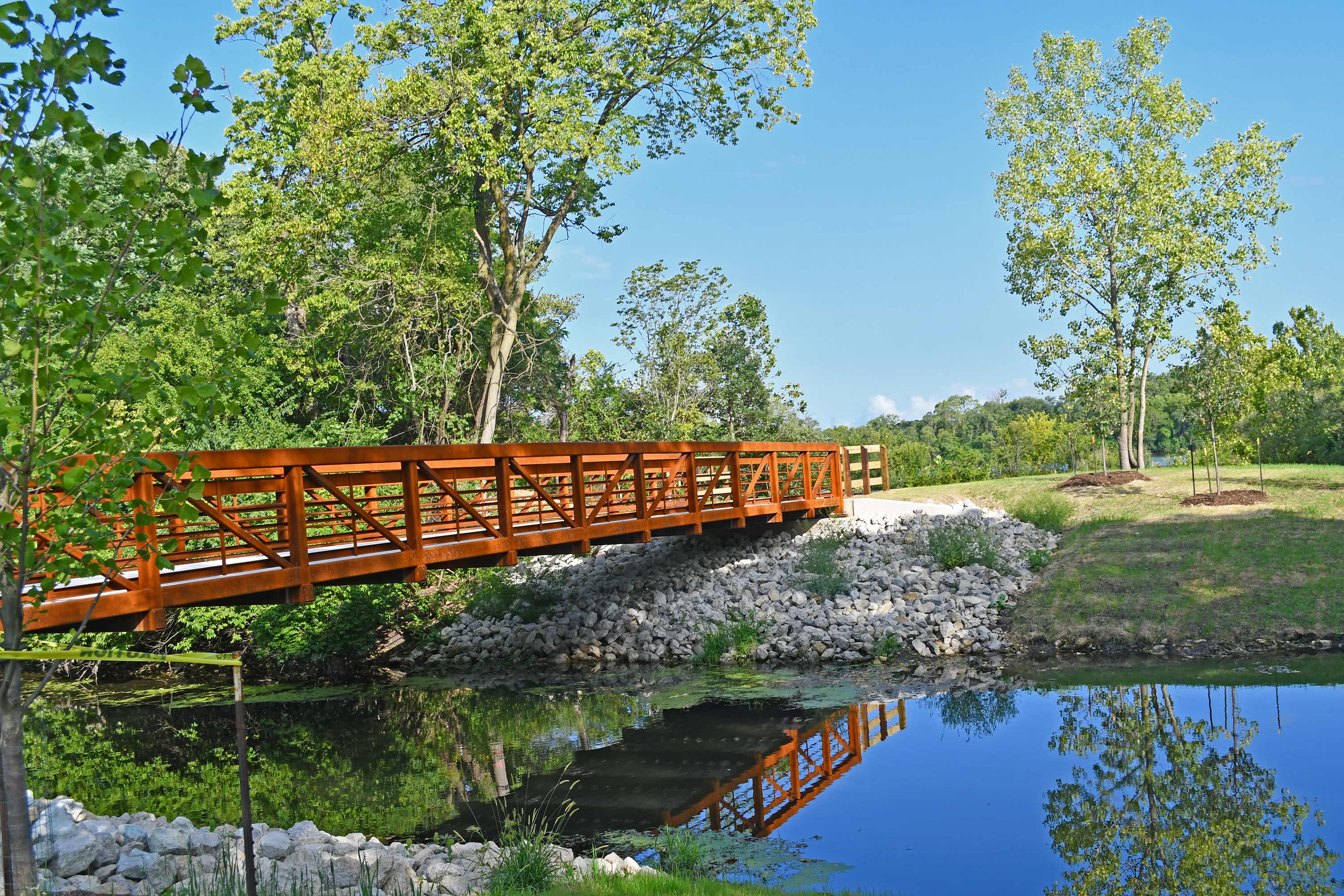 View of brown metal bridge over a canal.