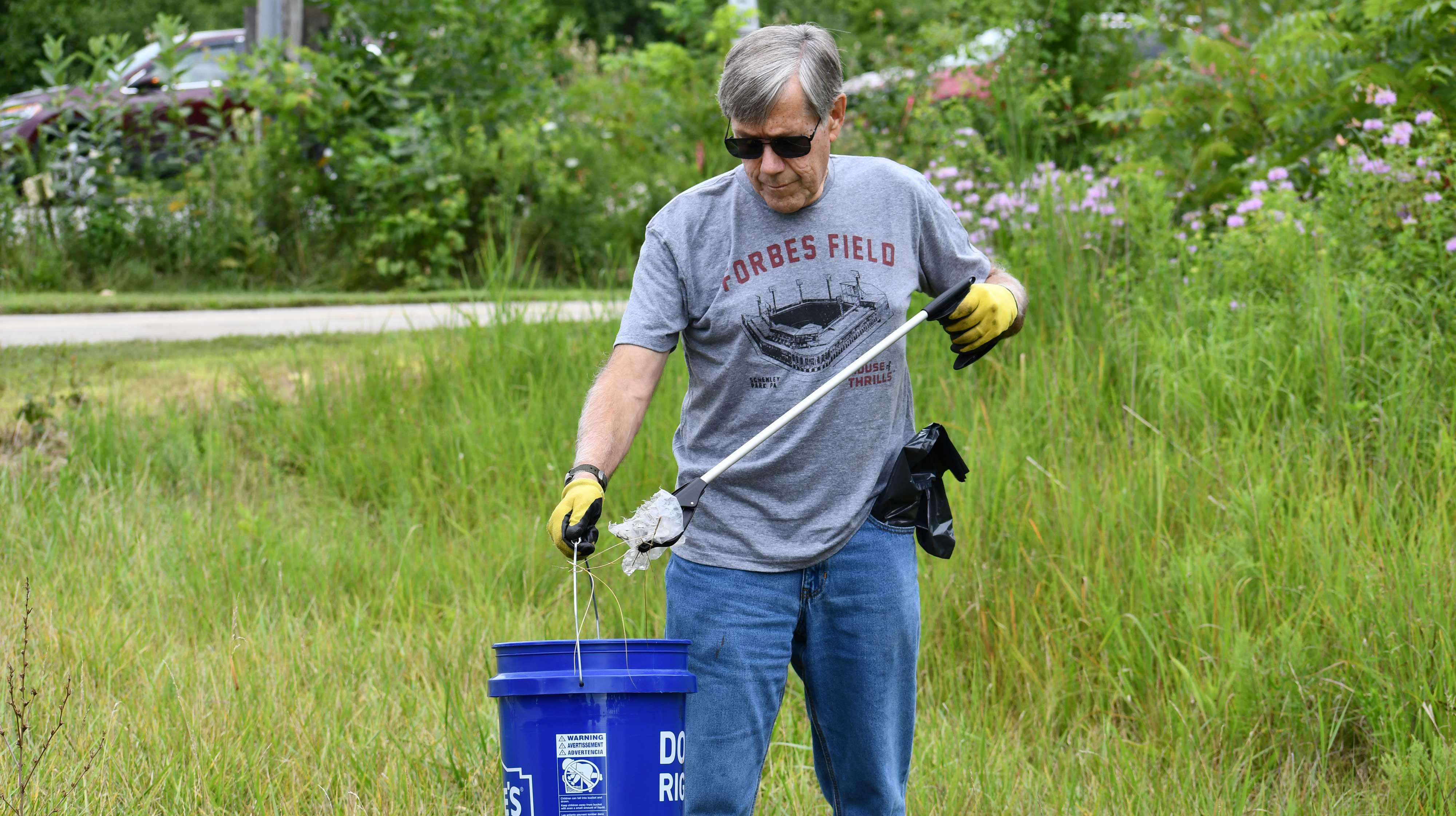 A volunteer picking up plastic in a preserve.
