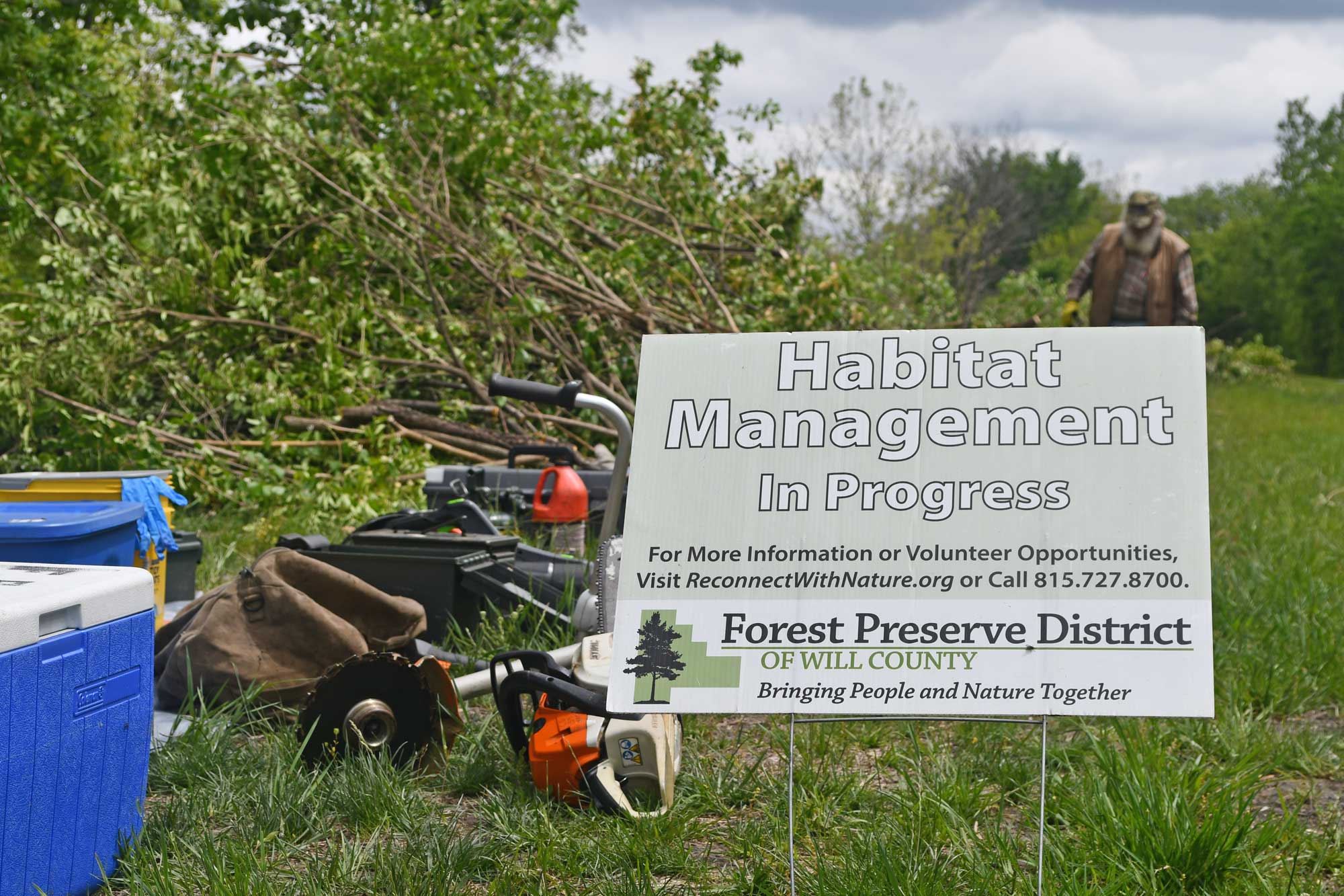 A sign that says habitat management is in view at a workday event. 