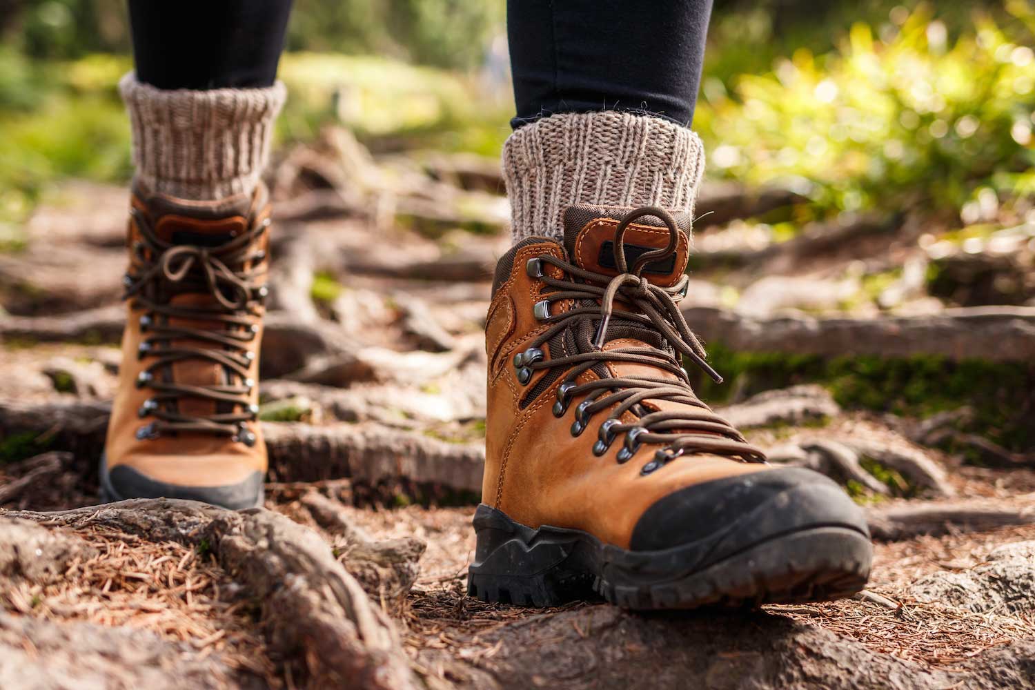 A closeup of boots walking along a dirt trail.