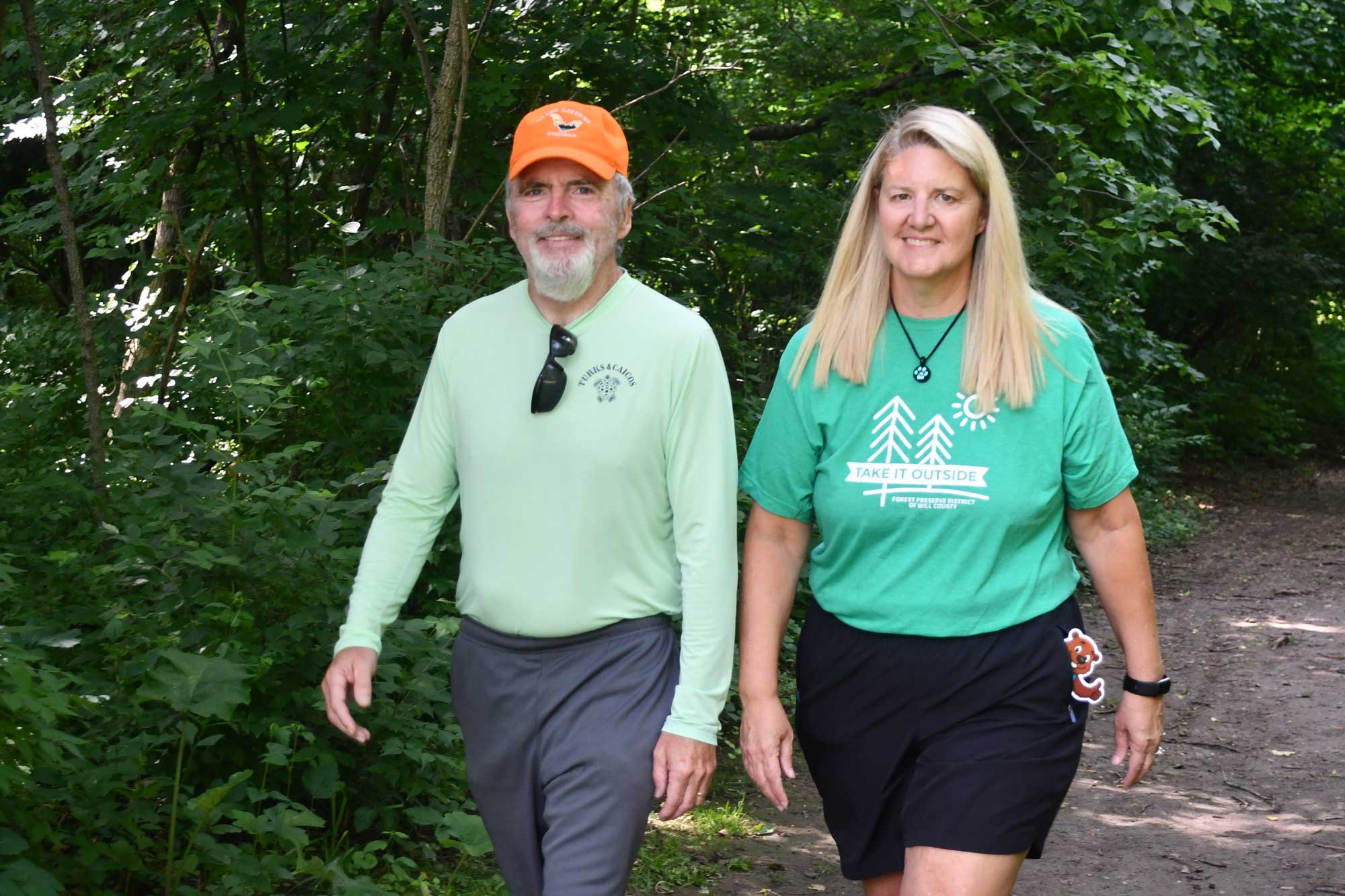 A man and a woman walk on a trail.