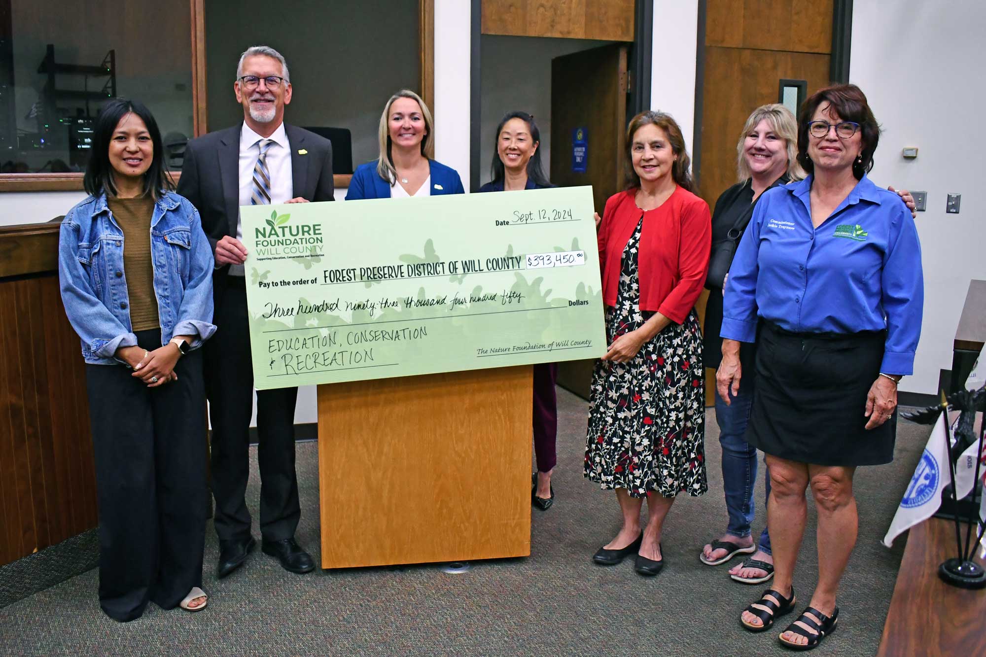 Recipients hold a large check.