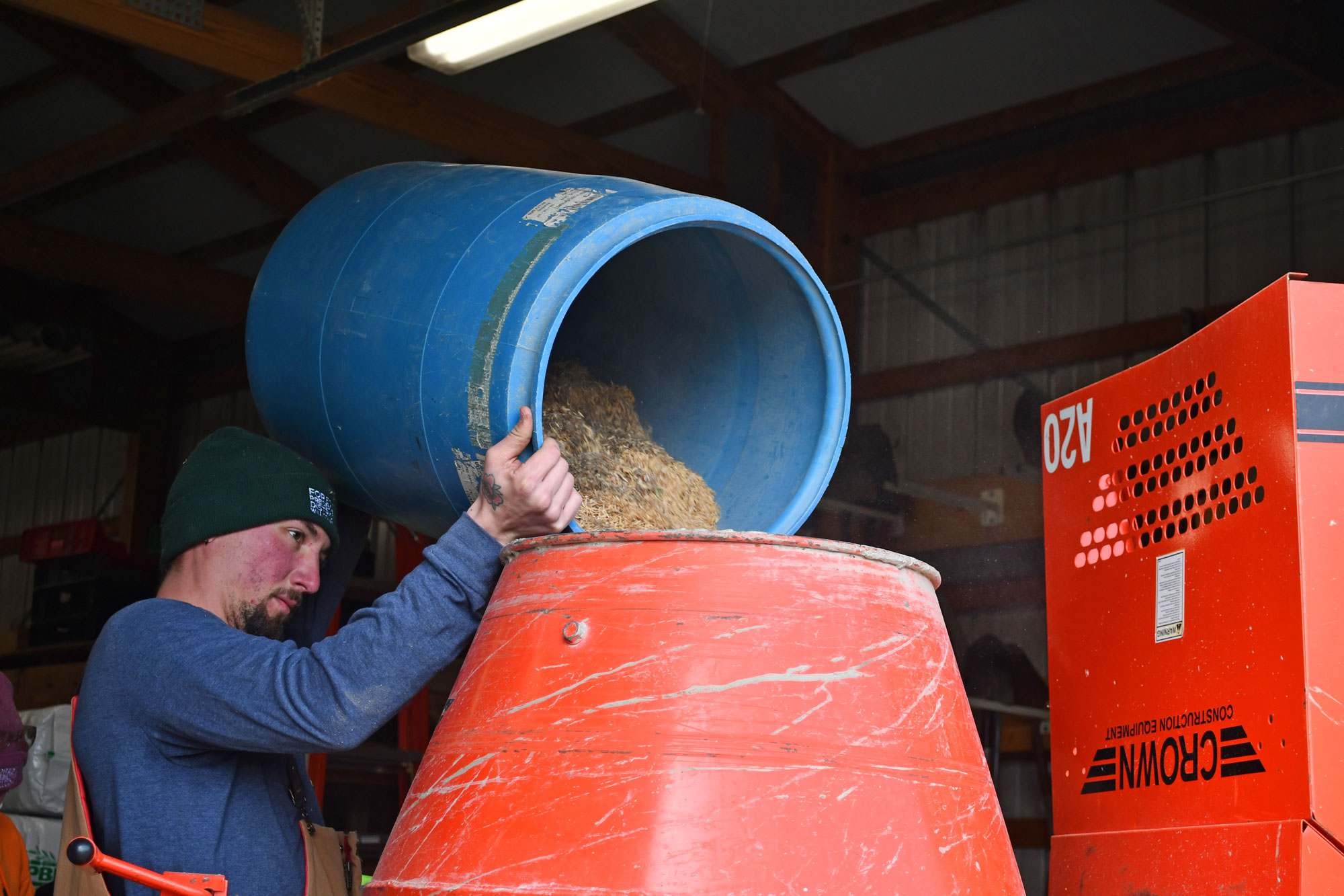 A man pours seed into a mixer.