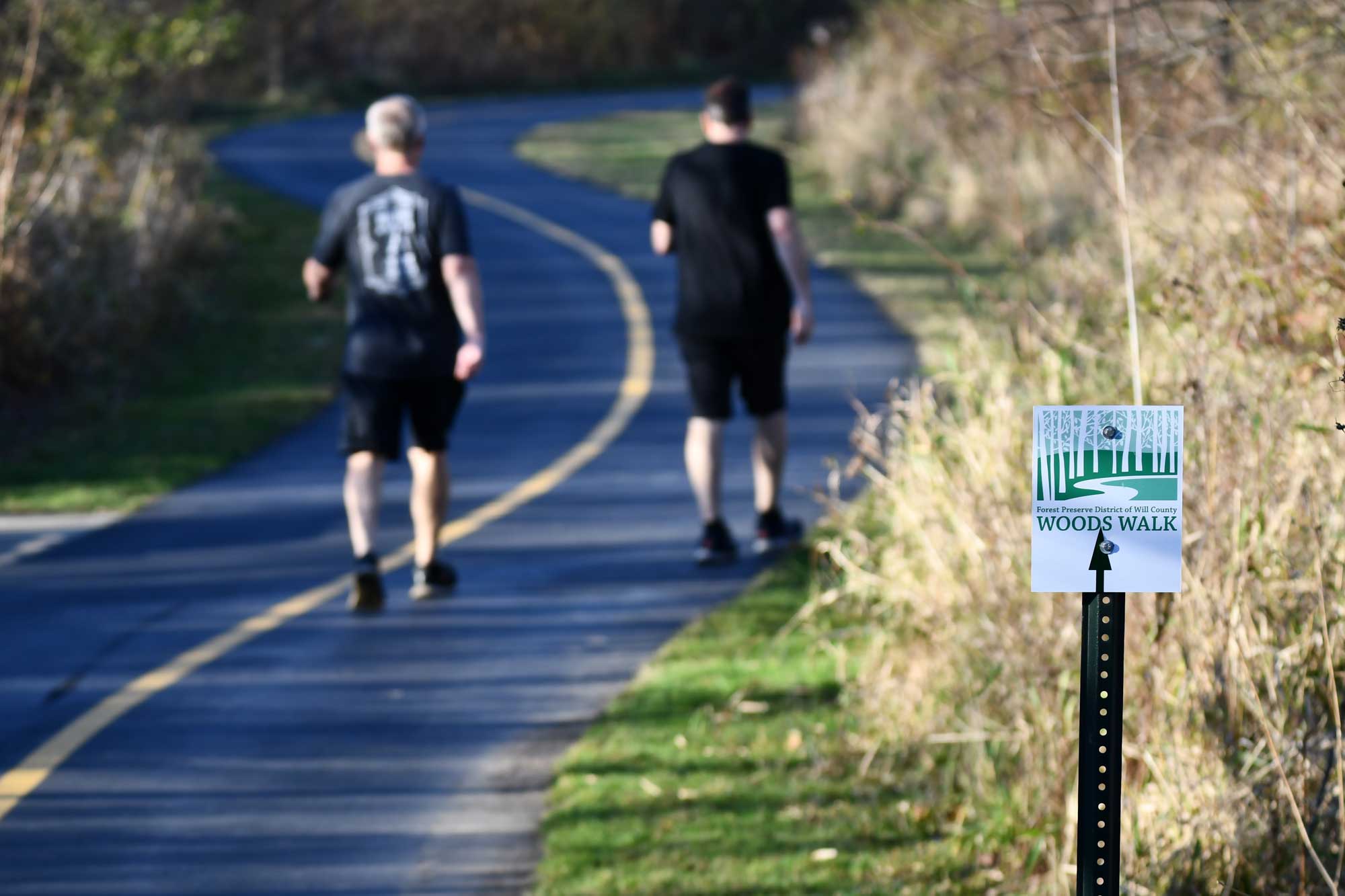 Two adults walking on a trail.