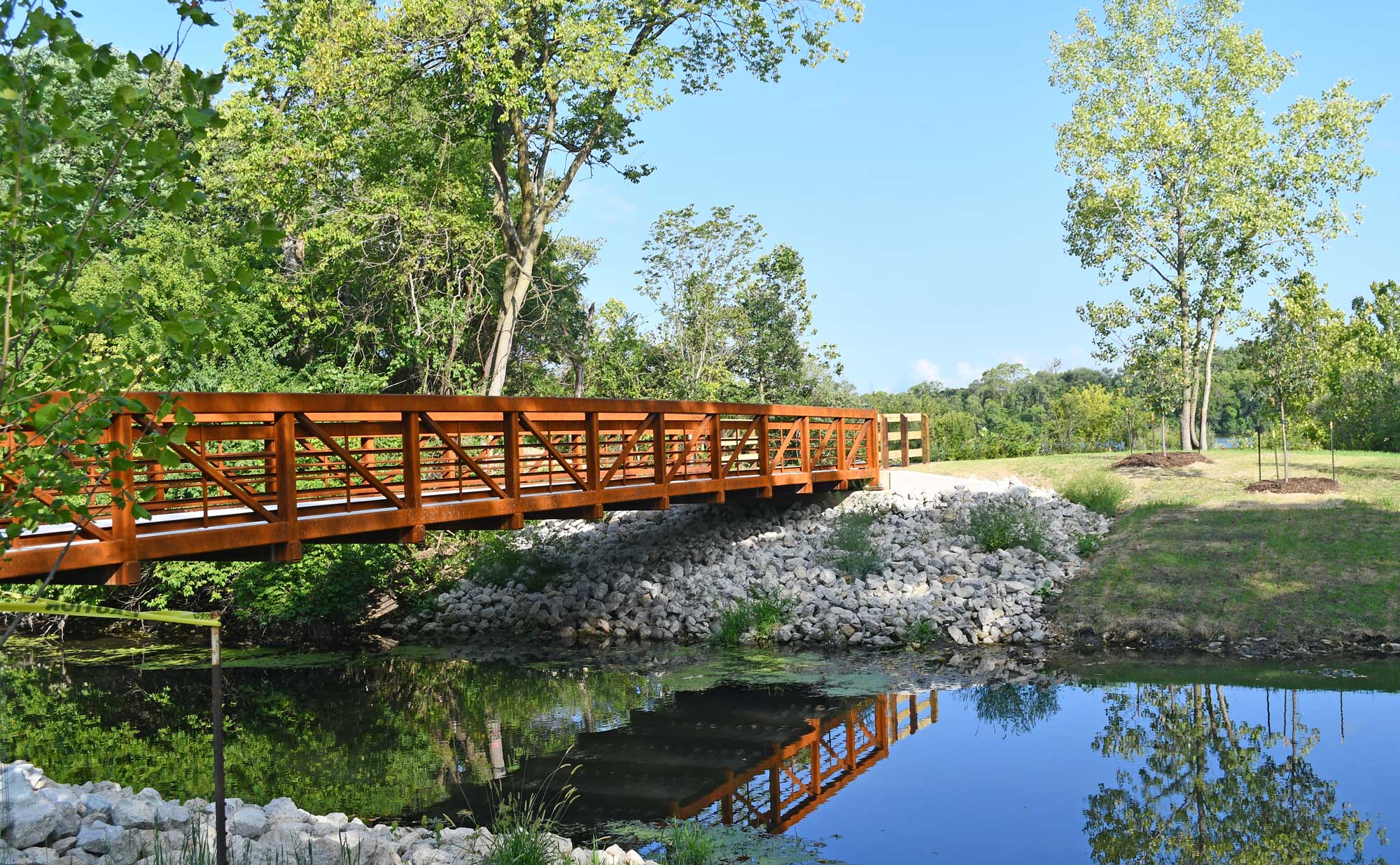 A pedestrian bridge over canal connects two trails. 