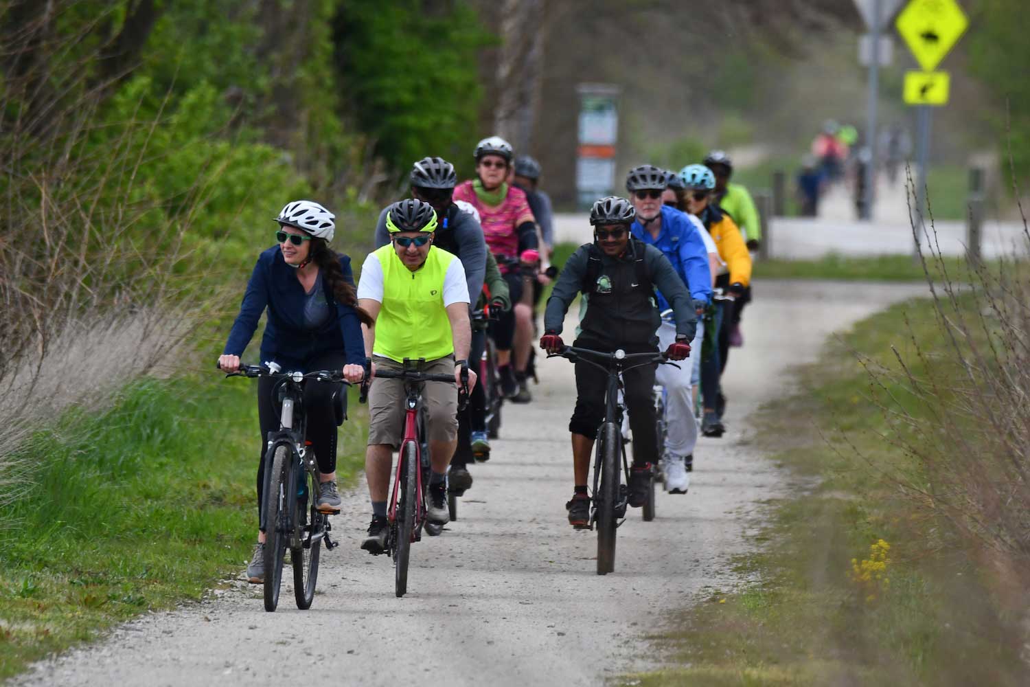 A group of people riding bikes along a crushed limestone path.