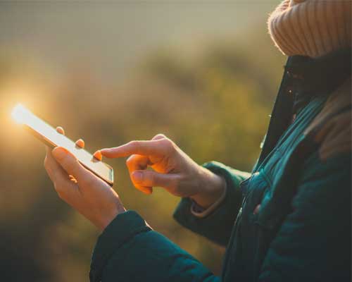 A woman scrolls on her phone