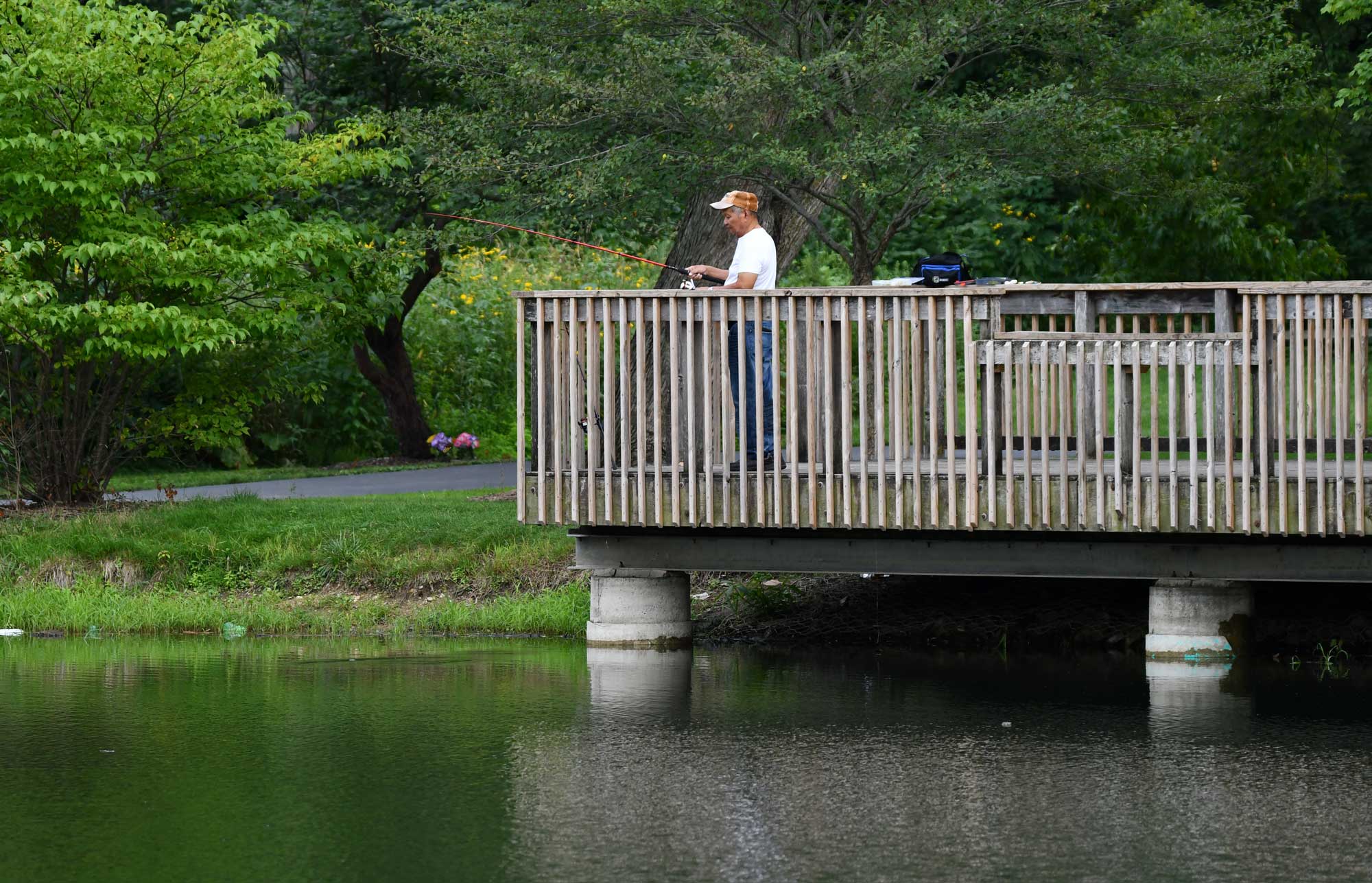 A man fishes off a pier. 