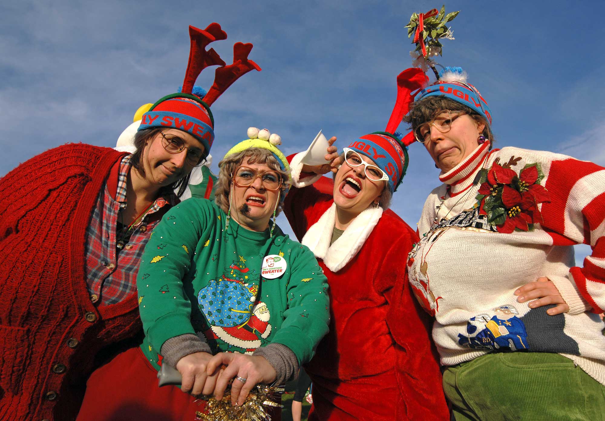 Women pose in ugly holiday sweaters