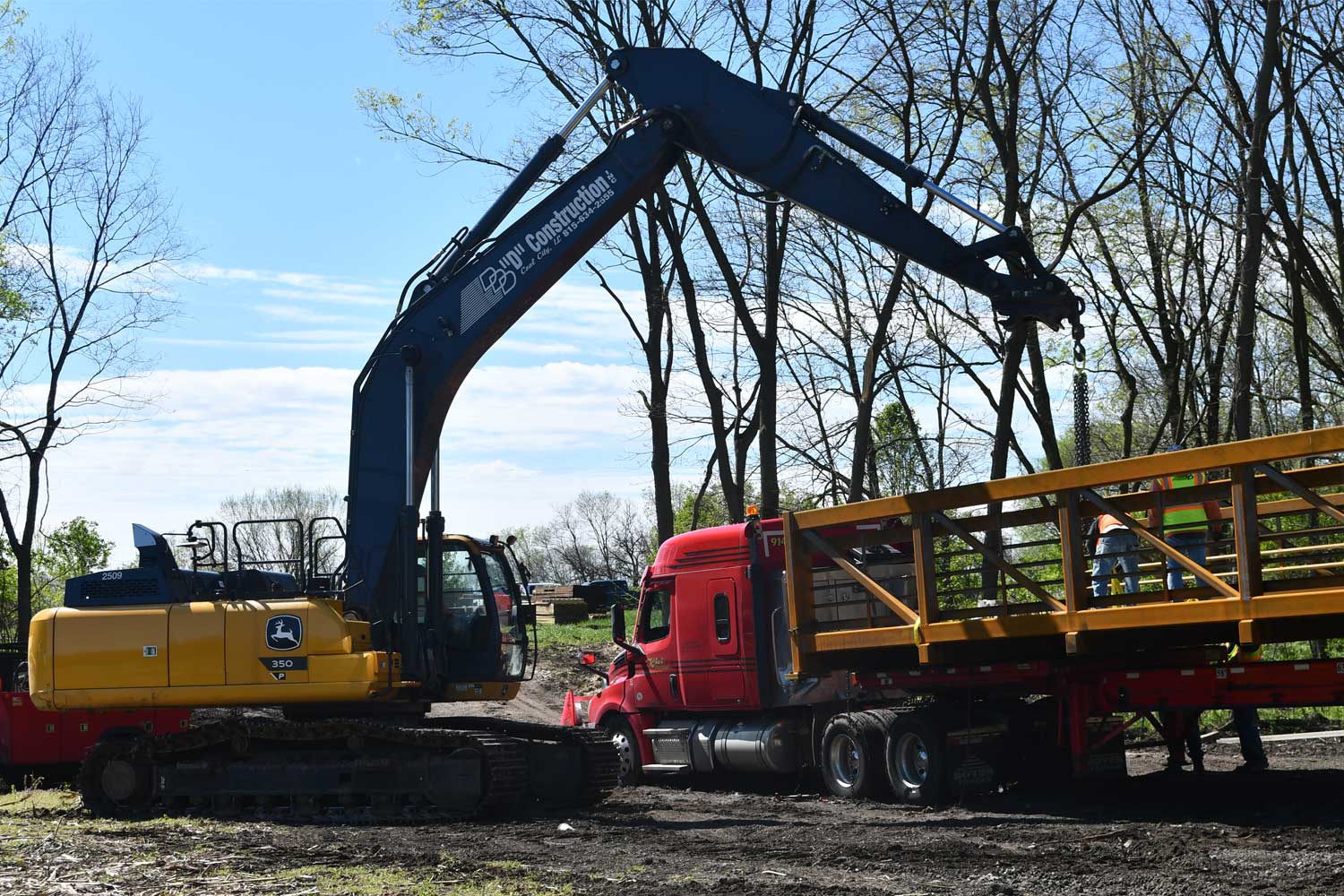 Construction vehicle starting to pick up bridge.